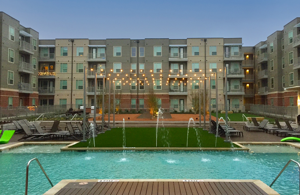 Luxury apartment complex pool with synthetic grass installed around it