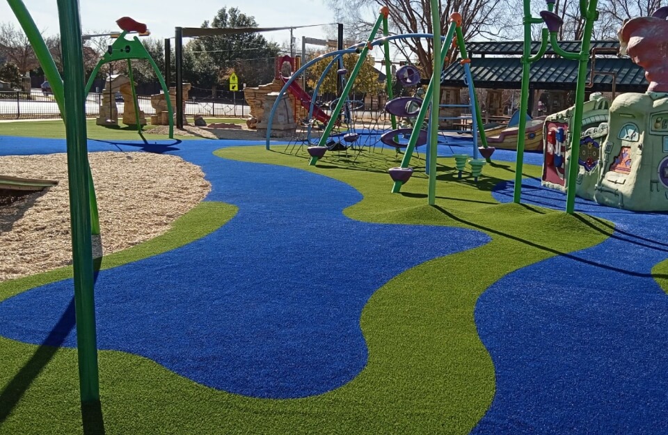 Green and blue playground turf installation in Dallas