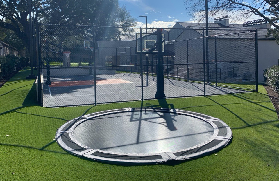 Artificial grass lawn next to backyard multi-sport game court