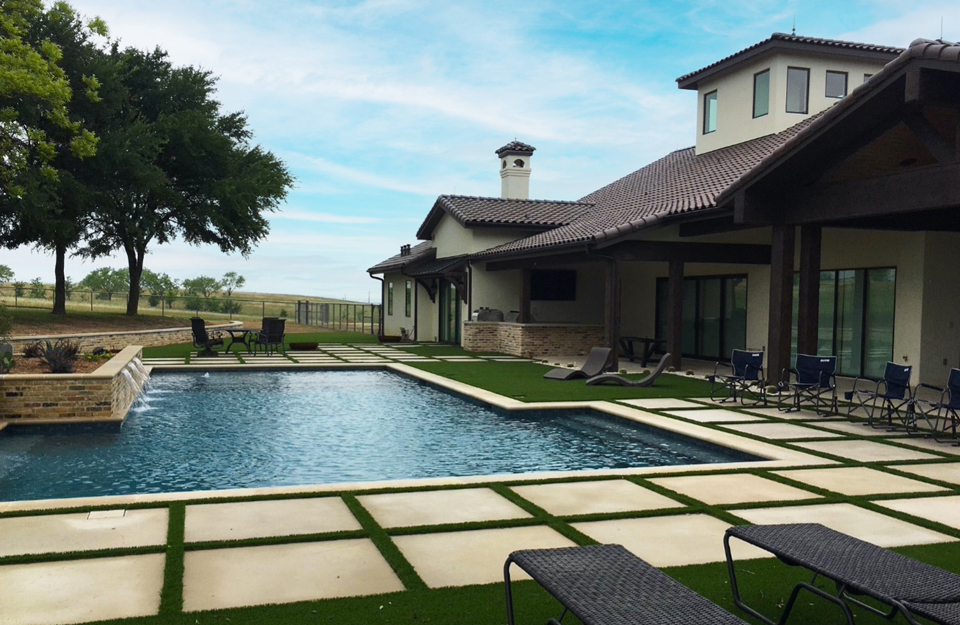 Synthetic grass installed around a backyard pool