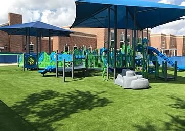Large playground with artificial grass installed around it