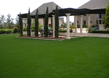 Covered outdoor living space with artificial turf lawn